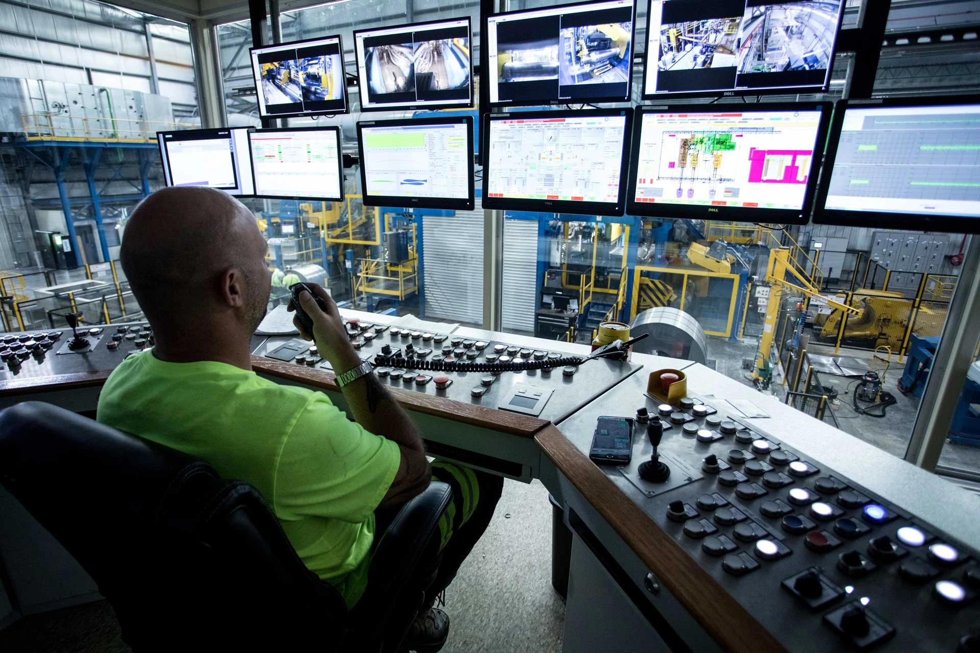 A manufacturing operator monitoring production from a control room