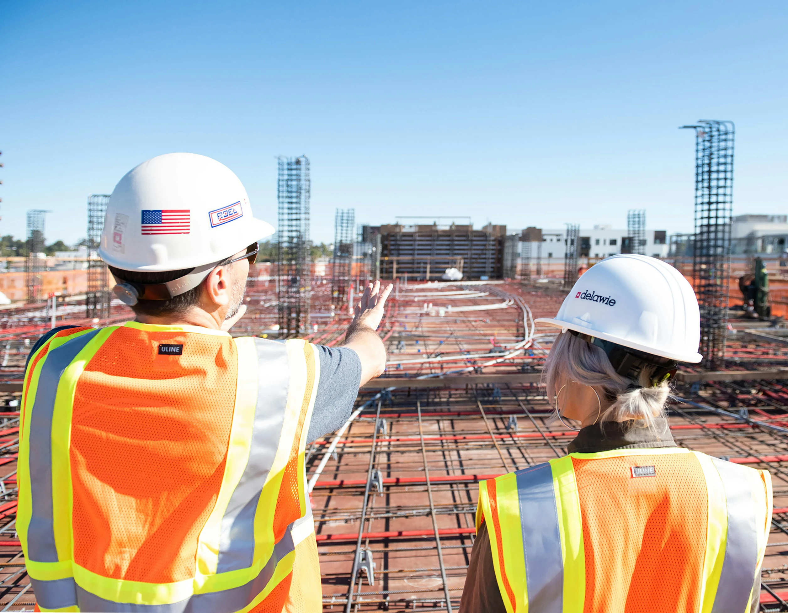 A worker in a hard hat looking out over a build site
